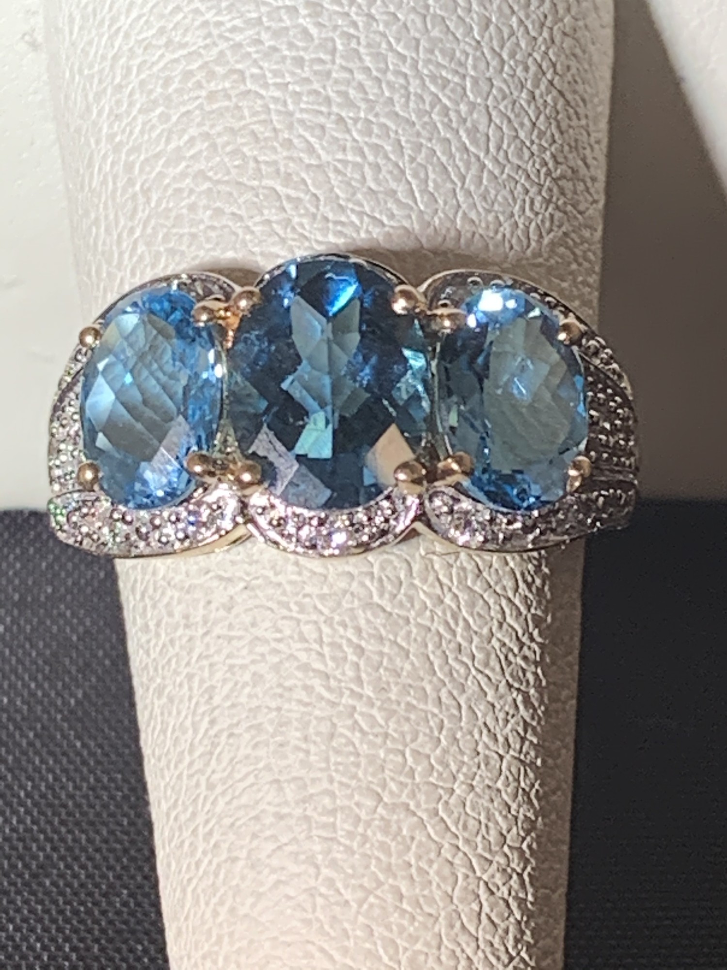 3 Oval Blue Topaz Ring with Diamond Halo Accent
Center Stone is London Blue Topaz and darker  than sides stones. There are 14 small Diamonds that create the illusion of  a Diamond Halo. Diamonds total approximately .10 carats.
14 karat Yellow Gold.
$590

Size 8   Can be sized up one size or down 2.