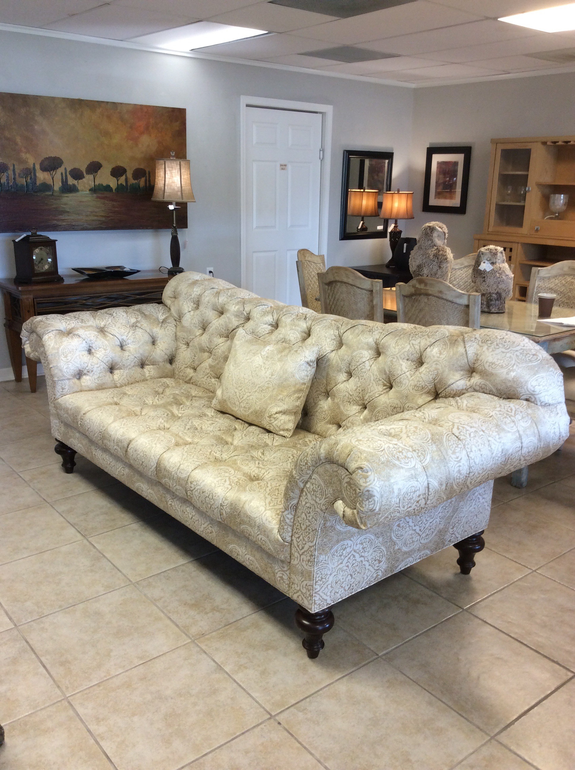 Upholstered in gold and cream, this formal sofa by Sherrill includes rolled arms, button-tufting and 3 accessory pillows.