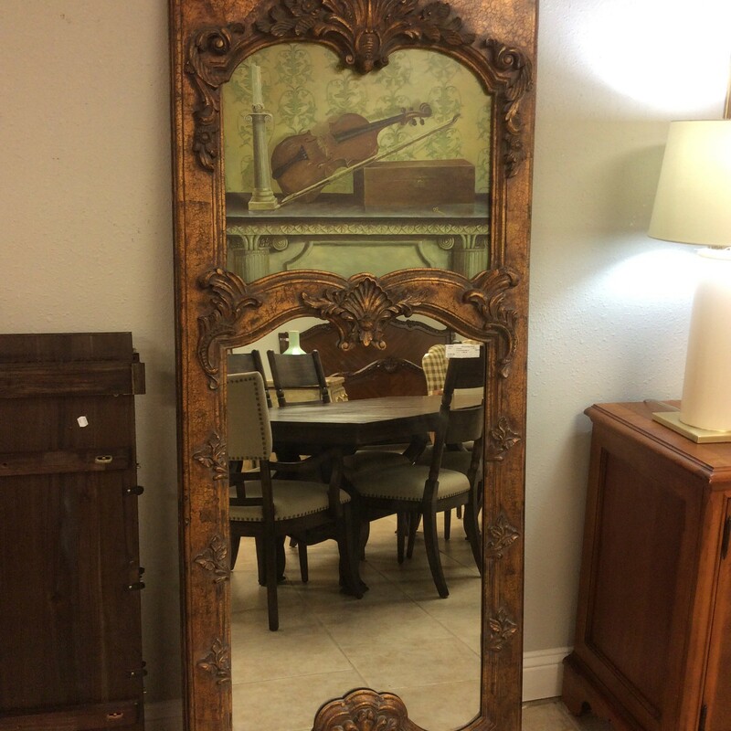 Absolutely stunning antiqued gold mirror with oil painting of a violin, candle and a box on the top and a mirror on the bottom. The frame is gold antiqued crackled surface with carvings.
Measures 32x72