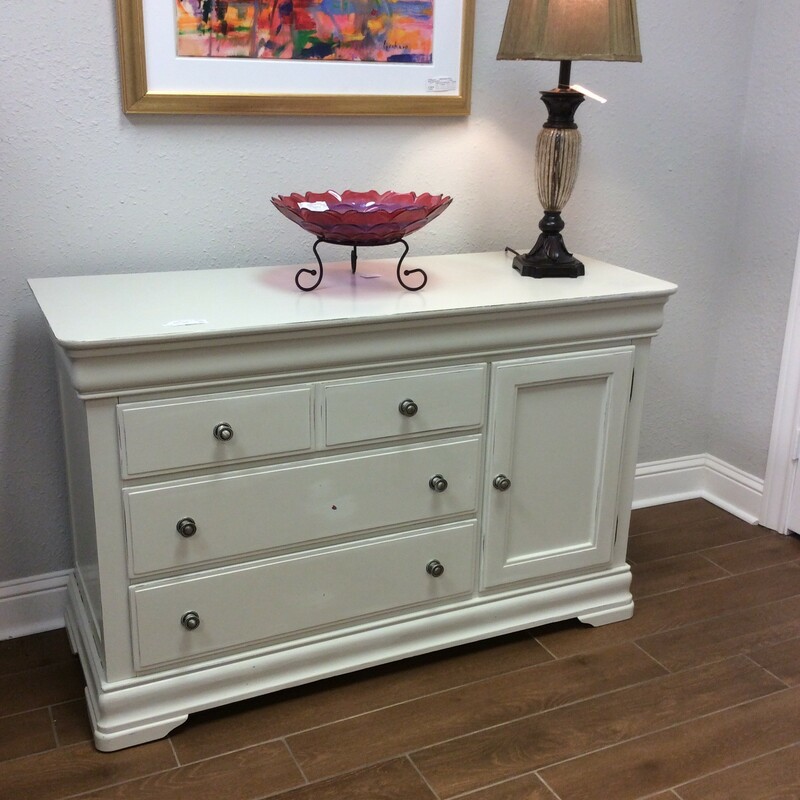 Oh, so shabby! This sweet dresser has been painted an off-white with some distressing giving it that weathered, timeless look that is so popular. It includes 3 spacious drawers and a cabinet with an adjustable shelf on the inside, the vintagy hardware a brushed nickel.