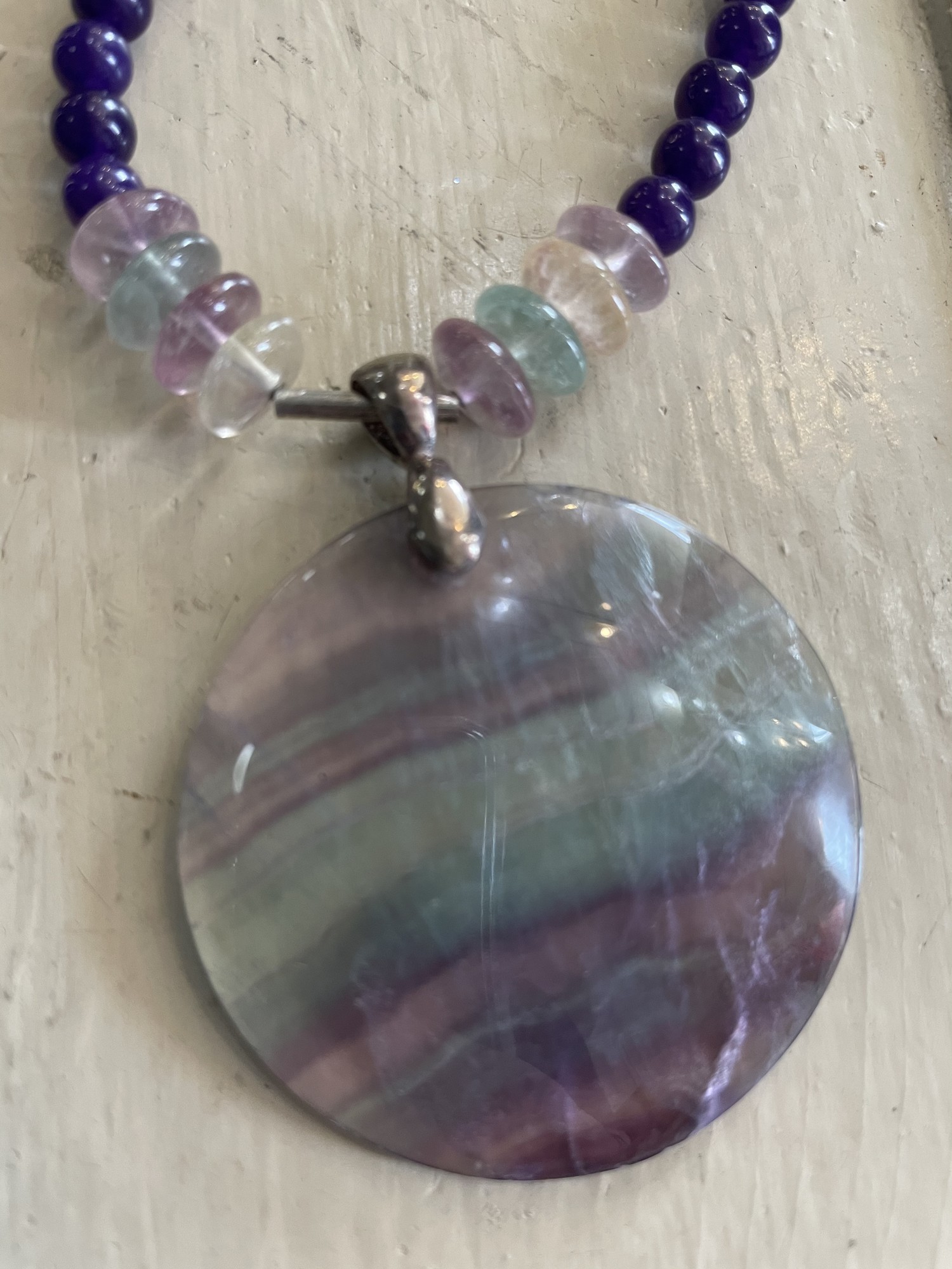 Rainbow Florite & Amythest Necklace
Beautifully hand crafted with sterling silver clasp, dividers and gem anchor
Purple, green and cream
Size: 11 Inches