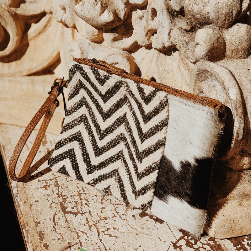 These Myra brand wristlets measure 6 by 9 inches and zipper shut. It is a pouch with one singular compartment inside. No two cowhides are alike, so the cowhide colors and patterns differ from wristlet to wristlet!
