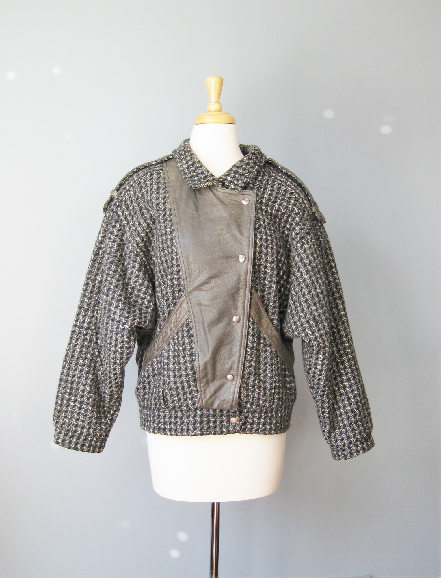 Classic motorcycle jacket with a twist - it's tweed and trimmed in gray leather
Leather Shoulder epaullettes.
Two side pockets
Snap front closure
Excellent condition, with some scratches on one spot of the leather trim.

Marked size M
Will probably fit as a cropped jacket unless you have very slim hips

Flat measurements:
Armpit to armpit: 23 .5in on the inside
Length: 25in

Thank you for looking
#10454