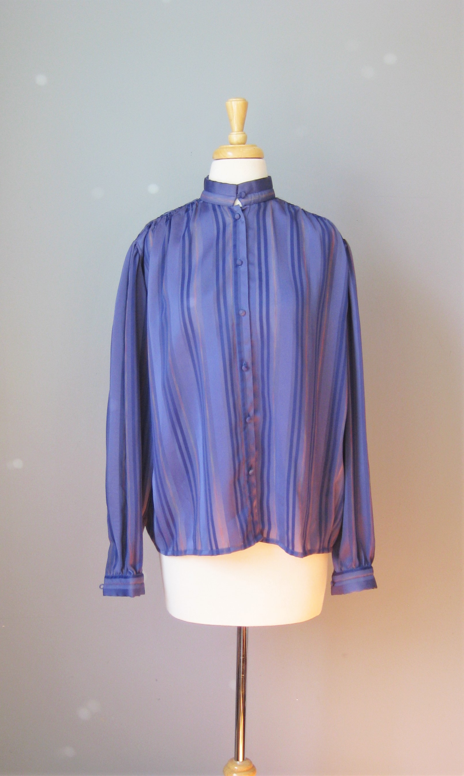 Simple semi sheer blouse in purple
Alternating stripes of purple , pink and sheer sections
High button collar
by Janine

Shoulder to shoulder: 17in
Armpit to Armpit: 24in
Waist: 24in
Length: 26in
Underarm sleeve seam length: 17in

Thanks for looking!

#14536