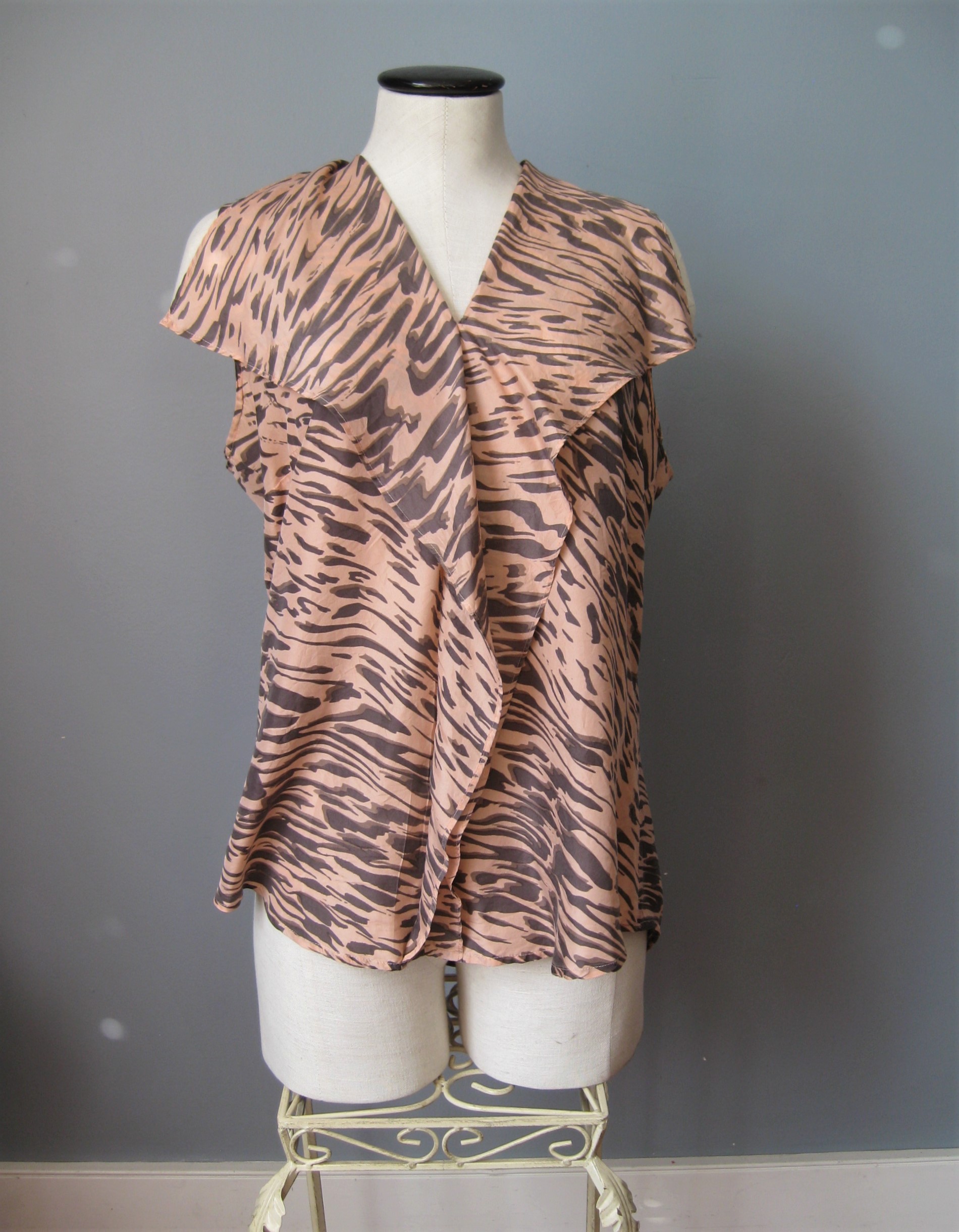 Pullover top from CAbi with a shawl collar and ruffle down the center front
Black tiger print on a peach background
100% silk

Size Medium
armpit to armpit: 21in
length: 26 3/4in

perfect condition
#1596