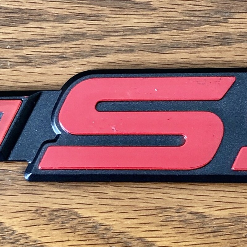 Chevy Stick On Decal, never been used and still has original adhesive strip cover!  Red & Black plastic.   Size: 7.25 W X .12 H