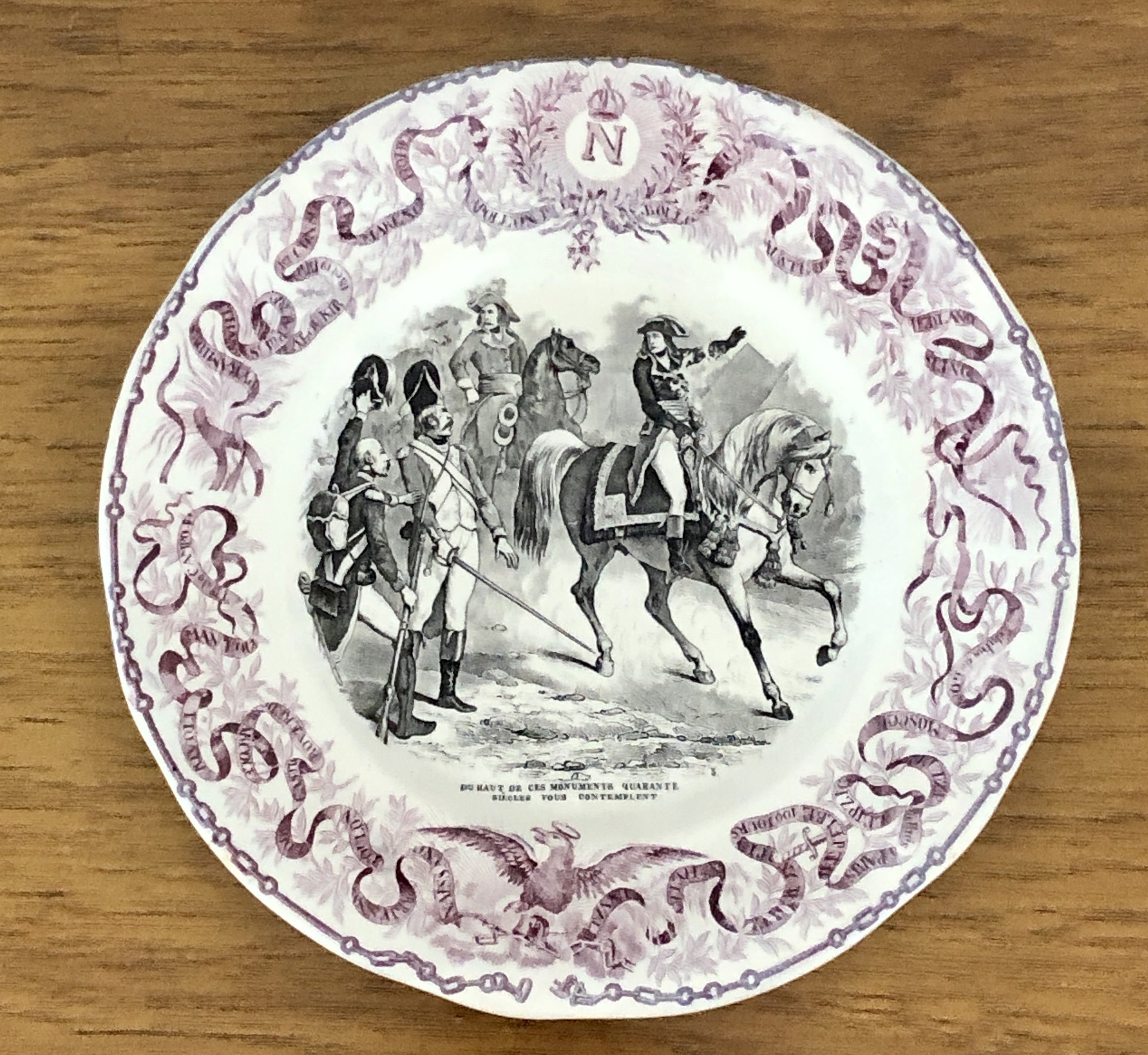 French Napoleon Commerative Assiettes Parlantes Plate. c.1840s Due Haut de Ces Monuments Qurante Siecles vous Contemplent
Assiettes Parlantes, or talking plates, are French transferware plates with sayings on them. The most collectible illustrate the life of a French hero such as the plates depicting Napoleon. Really unusual to find in purple. 8