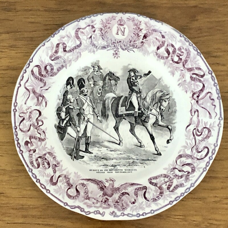 French Napoleon Commerative Assiettes Parlantes Plate. c.1840s Due Haut de Ces Monuments Qurante Siecles vous Contemplent
Assiettes Parlantes, or talking plates, are French transferware plates with sayings on them. The most collectible illustrate the life of a French hero such as the plates depicting Napoleon. Really unusual to find in purple. 8