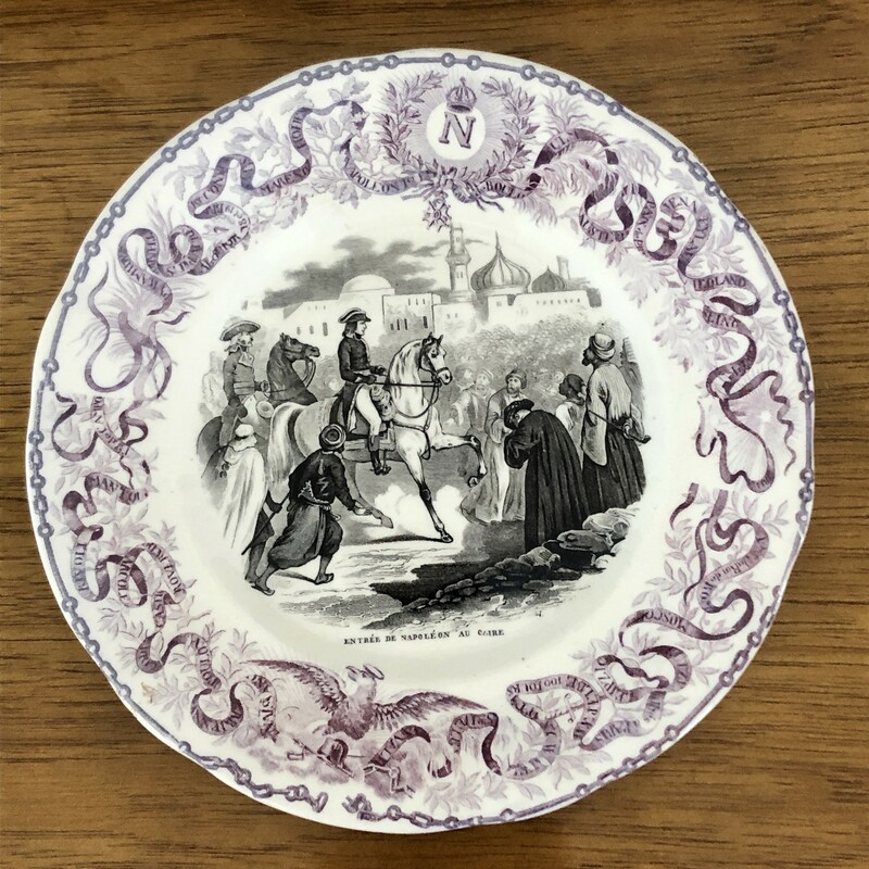French Napoleon Commerative Assiettes Parlantes Plate. c.1840s From the top of the Monuments
Assiettes Parlantes, or talking plates, are French transferware plates with sayings on them. The most collectible illustrate the life of a French hero such as the plates depicting Napoleon. Really unusual to find in purple. 8