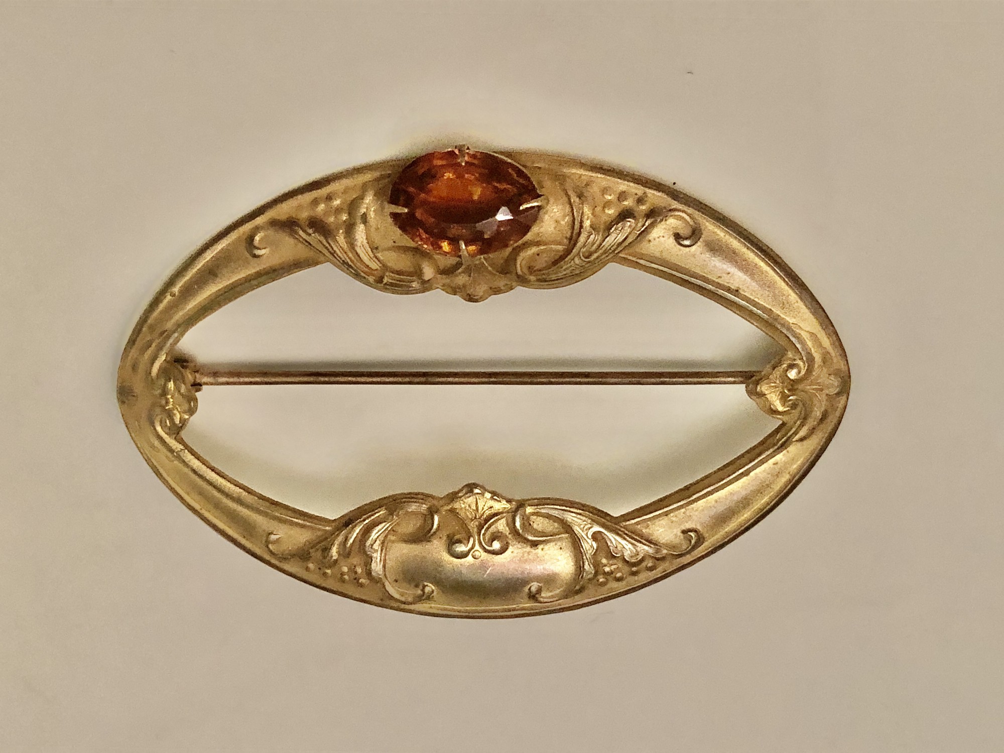 Victorian Brass on copper Sash Pin with amber glass bezel set cabochon.  Original c-clasp. Size: 3in X  2in
