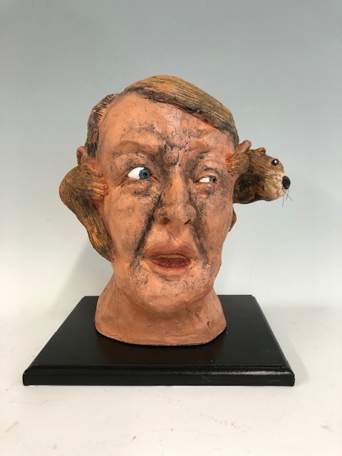 Title: In One Ear And Out The Other
Artist: Fred Freeman
Size: 9in w x  8in d x 12in h
Medium: Clay
Description: A three dimensional ceramic pun