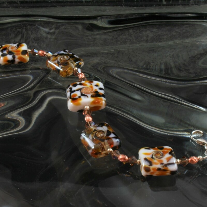 From the Serengetti collection of Gladmist Glass Design. Hand torched glass beads with sterling silver, Swarovski crystals and copper accents. Adjustable lobster clasp closure fits 7 1/2 or 8 inch wrist. Can be made to fit 8 1/2 inch wrist upon request.