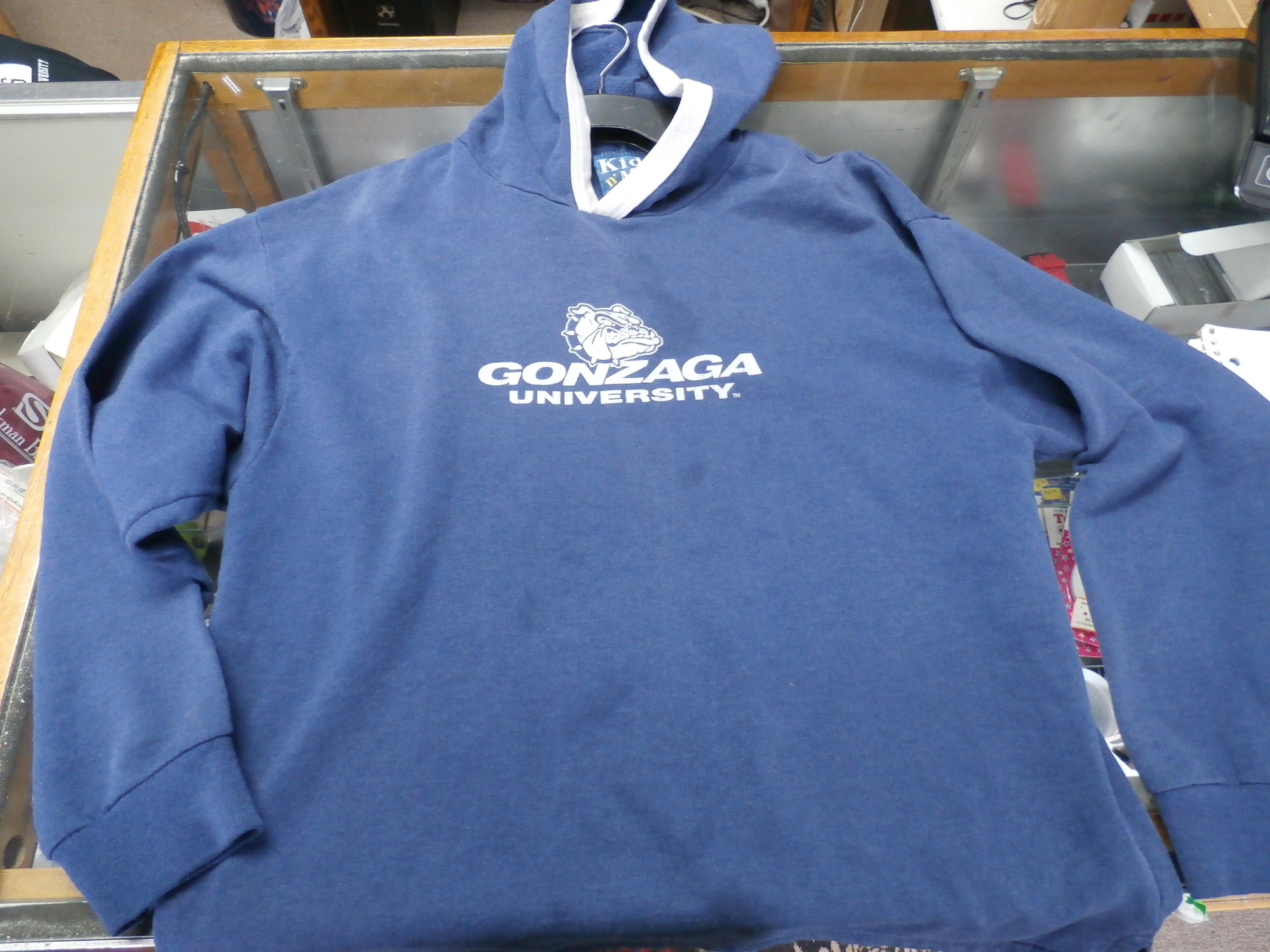 Gonzaga Bulldogs YOUTH hoodie blue size Large 14-16 poly cotton blend #22143
Rating: (see below) 4- Fair Condition
Team: Gonzaga Bulldogs
Player:  team
Brand: Kid N' Me
Size : Youth- Large 14-16 ( Measures Chest 18\" ; Length 21.5\") armpit to armpit; shoulder to hem
Color: blue
Style: long sleeve; screen printed
Material: 150% cotton 50% polyester
Condition: 4- Fair Condition; wrinkled; some pilling and fuzz; material is stretched and worn from wearing and washing; some fading and discoloration; large 3-inch stain next to logo; several smaller stains on front; logo is cracked (see photos)
Item #: 22143
Shipping: FREE