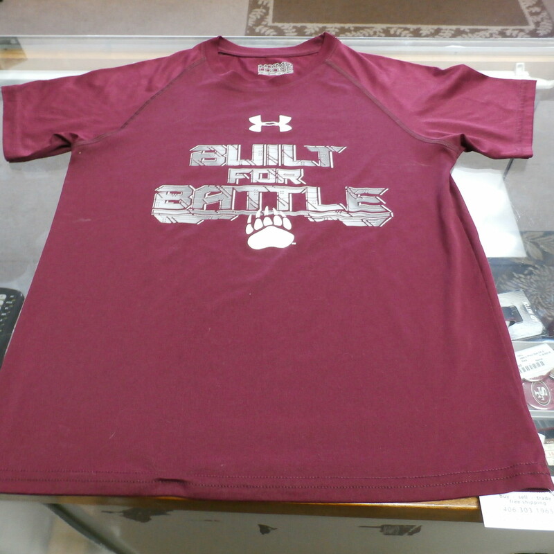 Montana Grizzlies \"Built For Battle\" YOUTH Under Armour Shirt Medium 23848
Rating:   (see below) 3 - Good Condition
Team: Montana Grizzlies
Player: n/a
Brand: Under Armour
Size: YOUTH - Medium(Measured Flat: Across chest 16\"; Length 22\")
Measured Flat: underarm to underarm; top of shoulder to bottom hem
Color: Maroon
Style: Short sleeve shirt; Screen pressed logo; Loose Fit
Material: 100% Polyester
Condition: 3 - Good Condition - wrinkled; material looks and feels good; light stains near the arm pits of the front; light pilling and fuzz; normal signs of wear; No rips or holes
Item #: 23828
Shipping: FREE