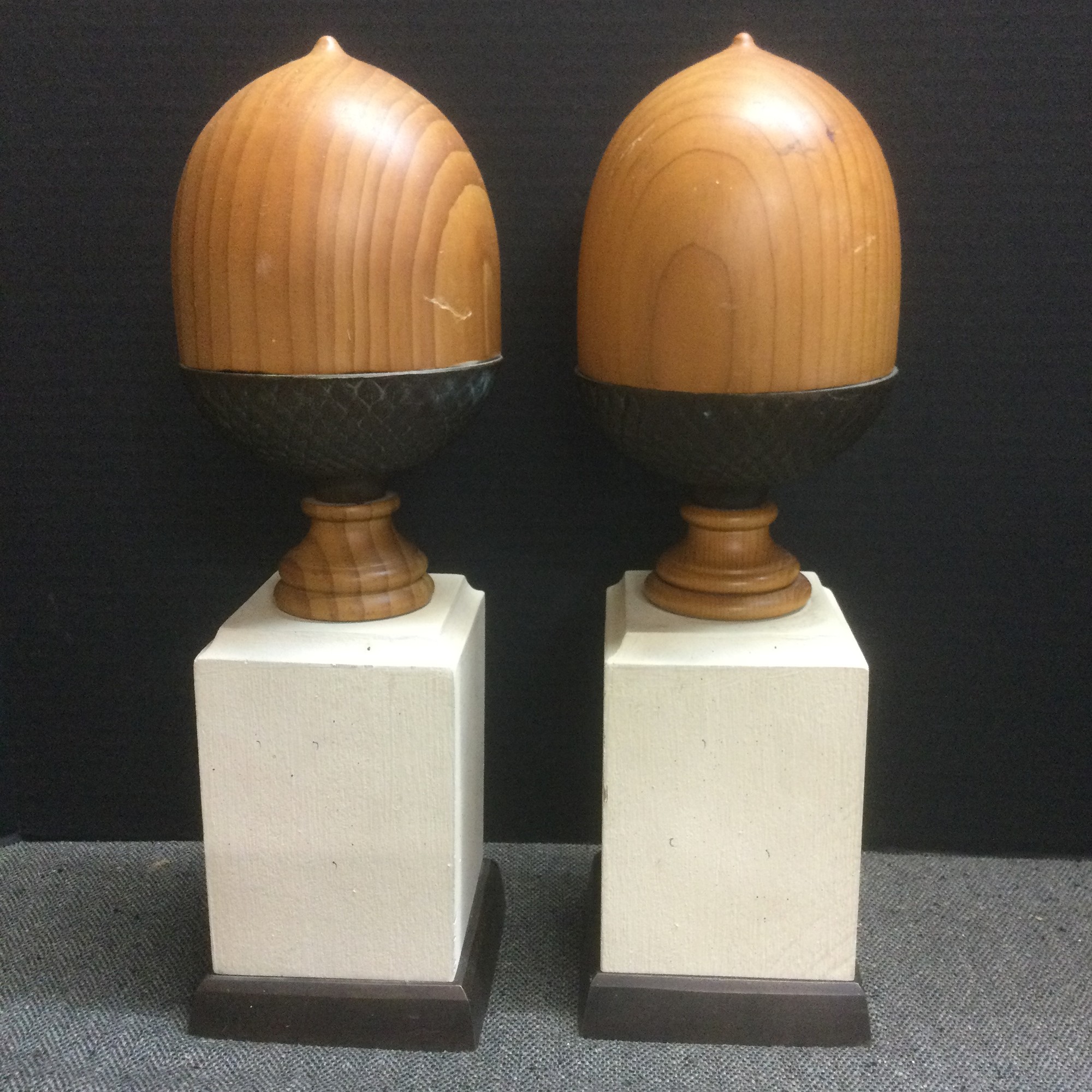 Carved acorn wood and brass finial sit a top their tall base. Propped on a shelf or mantle; this pair would stand out cradling a few of your favorite books. Lovely at 13 1/2h x 4w .