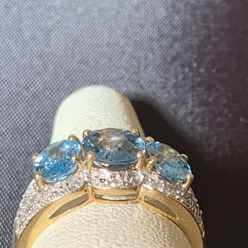 3 Oval Blue Topaz Ring with Diamond Halo Accent<br />
Center Stone is London Blue Topaz and darker  than sides stones. There are 14 small Diamonds that create the illusion of  a Diamond Halo. Diamonds total approximately .10 carats.<br />
14 karat Yellow Gold.<br />
$590<br />
<br />
Size 8   Can be sized up one size or down 2.