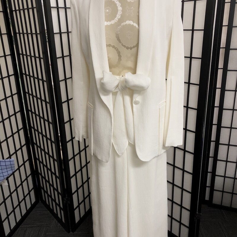 HALSTON HERITAGE  CRINKLED IVORY SLACK SUIT - SIZE 2/4.
This has a crinkled style material, ivory in color exposing  a look of understated classic elegance.  The jacket has a elongated V-neck, 2\" wide lapels,  one button closure, 2 unique large front pocket with a   7.5\" slit in back.. Estimated measurements:  length = 28\", sleeve length = 25, fully lined.  Inside label reads size XS with additional composition label of viscose, nylon .and poly.  High rise slacks  of course have same composition of viscose, nylon and poly, fully lined, a wide leg which elongates the leg yet so very stylish belted effect at waist .with belt loops, concealed back zipper, 2 hook closures, , generous material sash belt which allows your choice of tie  whether it be a bow or
simple tie (please refer to pictures).. Estimate measurements:  hip = 29\", waist = 27\", rise = 14\", leg opening = 28\".  Inside tag reads a size 4.  Halston's design principles are truly on display.  Can be worn with a bold brooch, exquisite scarf or shawl and certainly a multitude of pearls.  So easy to enjoy.