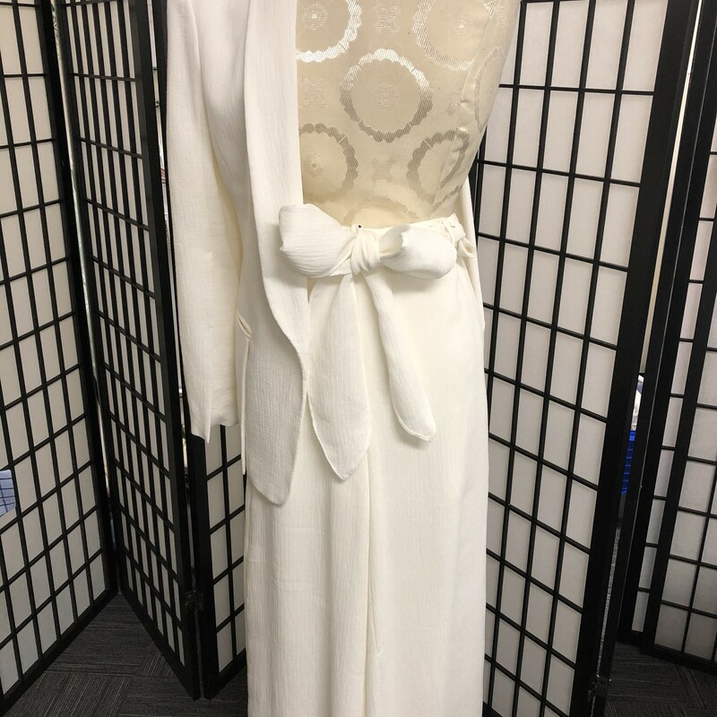 HALSTON HERITAGE  CRINKLED IVORY SLACK SUIT - SIZE 2/4.<br />
This has a crinkled style material, ivory in color exposing  a look of understated classic elegance.  The jacket has a elongated V-neck, 2\" wide lapels,  one button closure, 2 unique large front pocket with a   7.5\" slit in back.. Estimated measurements:  length = 28\", sleeve length = 25, fully lined.  Inside label reads size XS with additional composition label of viscose, nylon .and poly.  High rise slacks  of course have same composition of viscose, nylon and poly, fully lined, a wide leg which elongates the leg yet so very stylish belted effect at waist .with belt loops, concealed back zipper, 2 hook closures, , generous material sash belt which allows your choice of tie  whether it be a bow or<br />
simple tie (please refer to pictures).. Estimate measurements:  hip = 29\", waist = 27\", rise = 14\", leg opening = 28\".  Inside tag reads a size 4.  Halston's design principles are truly on display.  Can be worn with a bold brooch, exquisite scarf or shawl and certainly a multitude of pearls.  So easy to enjoy.