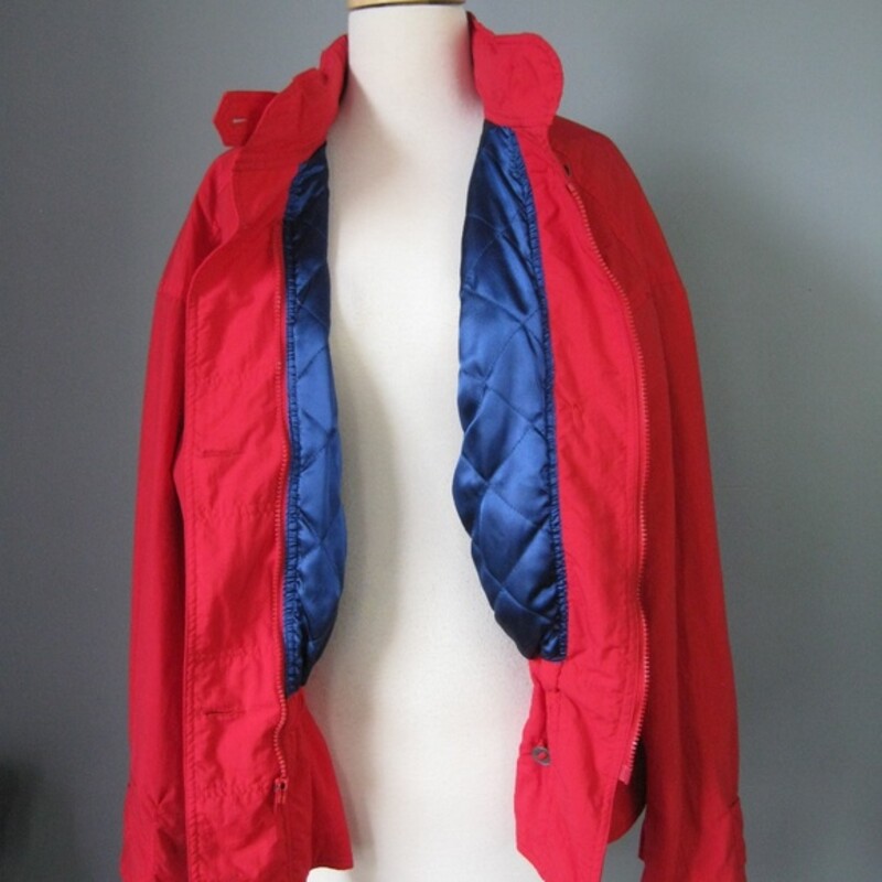 Cinchable red ski shell or jacket  from the 1990s<br />
Brand: At Ease<br />
Zippered front with metal buttons<br />
Hood hides in the zipper around the neck<br />
Blue Quilted satin lining<br />
Bright Red<br />
Size Large<br />
Made in Malaysia<br />
<br />
Flat measurements (Please double where appropriate):<br />
Armpit to armpit: 29in<br />
Length: 25 3/4in<br />
<br />
Thanks for looking!<br />
#25514