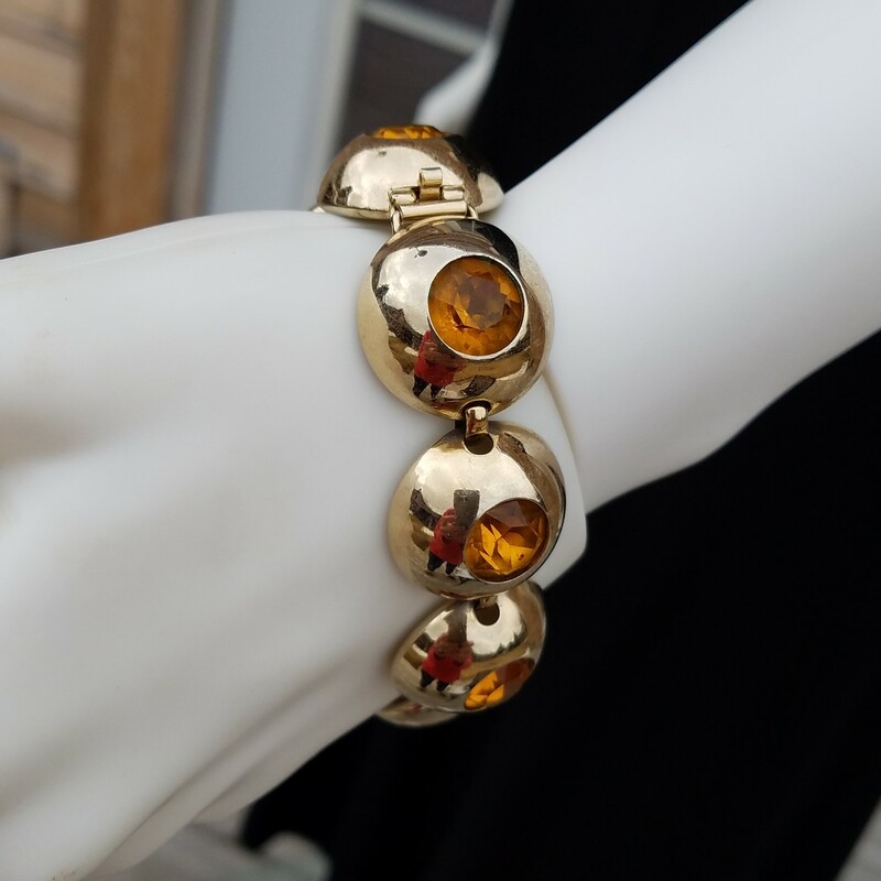 FUN BRACELET WITH HALF BALL PIECES WITH CITRINE COLORED STONES
Vintage Napier bracelets are among the most coveted in the genre of vintage costume jewelry. The range in design styles and execution is unparalleled. For this reason, the Napier bracelet has experience a long history in of being at the top of fashion jewelry.