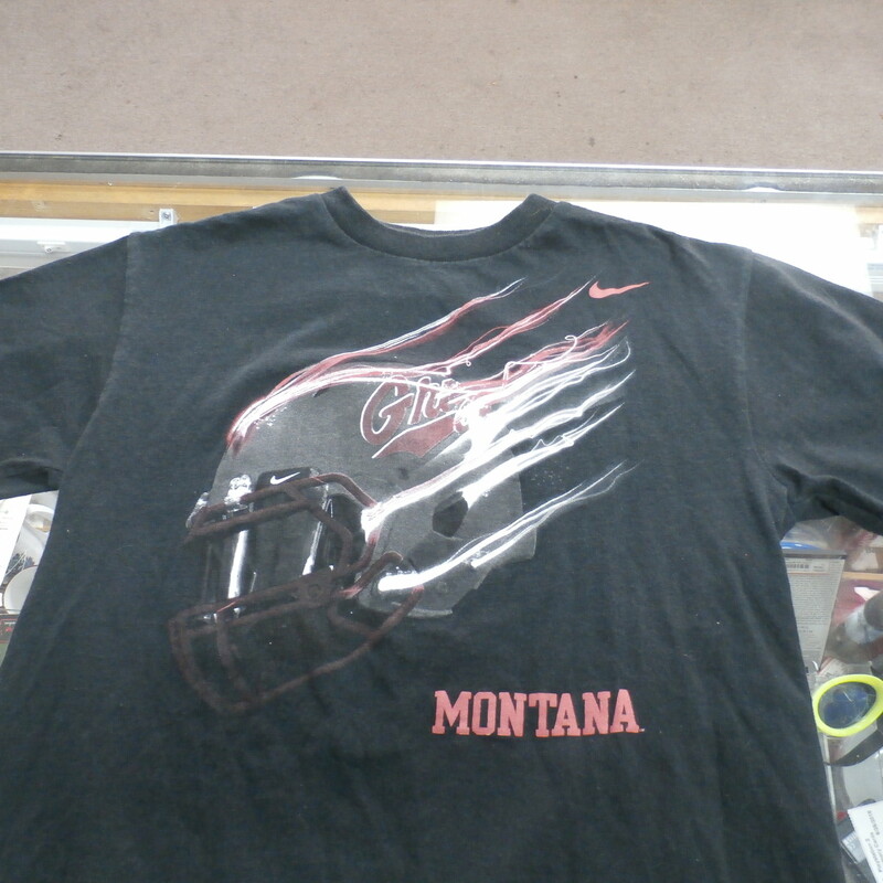 Montana Grizzlies Nike YOUTH Short Sleeve Shirt Size Large Black #26950<br />
Rating: (see below) 3 - Good Condition<br />
Team: Montana Grizzlies<br />
Player: N/A<br />
Brand: Nike<br />
Size: Large YOUTH - (Measured Flat: chest 17\", length 22\")<br />
Measured laying flat: armpit to armpit; top of shoulder to bottom hem<br />
Color: Black<br />
Style: screen pressed shirt<br />
Material: Cotton? - Tag is hard to read<br />
Condition: 3 - Good Condition: faded and discolored; pilling and fuzz; material feels coarse; material is stretched; screen pressed tag is faded and hard to read; definite signs of use<br />
Item #: 26950<br />
Shipping: FREE