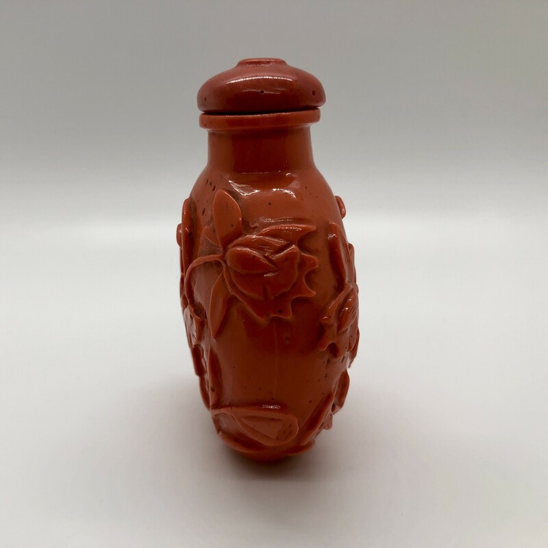 Wonderful large c. 19th century Chinese Qing Dynasty Peking glass snuff bottle made to imitate coral. Carved with  lotus flowers and leaves. Lid has a small chip.<br />
3in x 2.25in