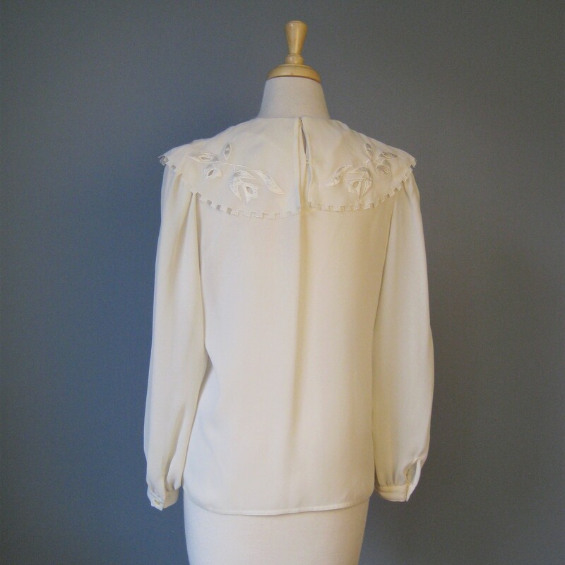 Pretty blouse with a large draped collar with satin appliques and cutouts<br />
Buttons are in the back<br />
Small Shoulder pads<br />
Polyester<br />
By Nilani<br />
Marked size 4 (seems about right)<br />
Flat measurements, please double where approrpriate:<br />
Armpit to Armpit: 19.5in<br />
Length: 22 31/4in<br />
width at hem: 19 1/2in<br />
Underarm sleeve seam length: 17.5<br />
shoulder to shoulder: 13 3/4in<br />
<br />
Excellent condition<br />
thank for looking!<br />
#15758