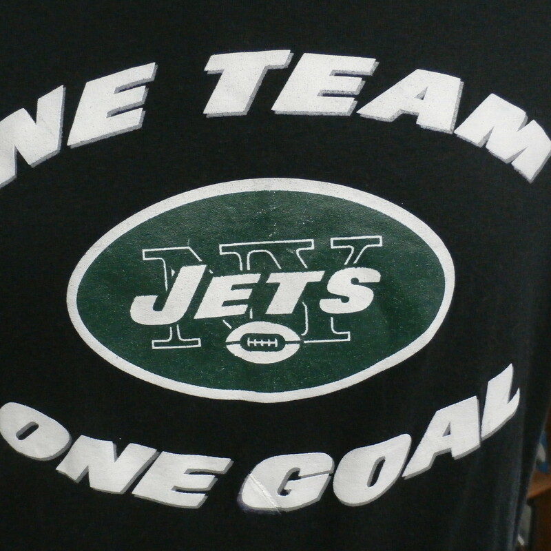 New York Jets \"One Team\" New Era shirt black size tag missing polyblend #29282<br />
Rating: (see below) 3- Good Condition<br />
Team: New York Jets<br />
Player: n/a<br />
Brand: New Era<br />
Size: Tag missing- (Measured Flat: Across chest 21\"; Length 28\")<br />
Measured Flat: underarm to underarm; top of shoulder to bottom hem<br />
Color: black<br />
Style: short sleeve; screen printed<br />
Material: 50% polyester 38% cotton 12% rayon<br />
Condition: 3- Good Condition: minor wear and fuzz from use; printing defect on \"G\" on front (see photos)<br />
Item #: 29282<br />
Shipping: FREE
