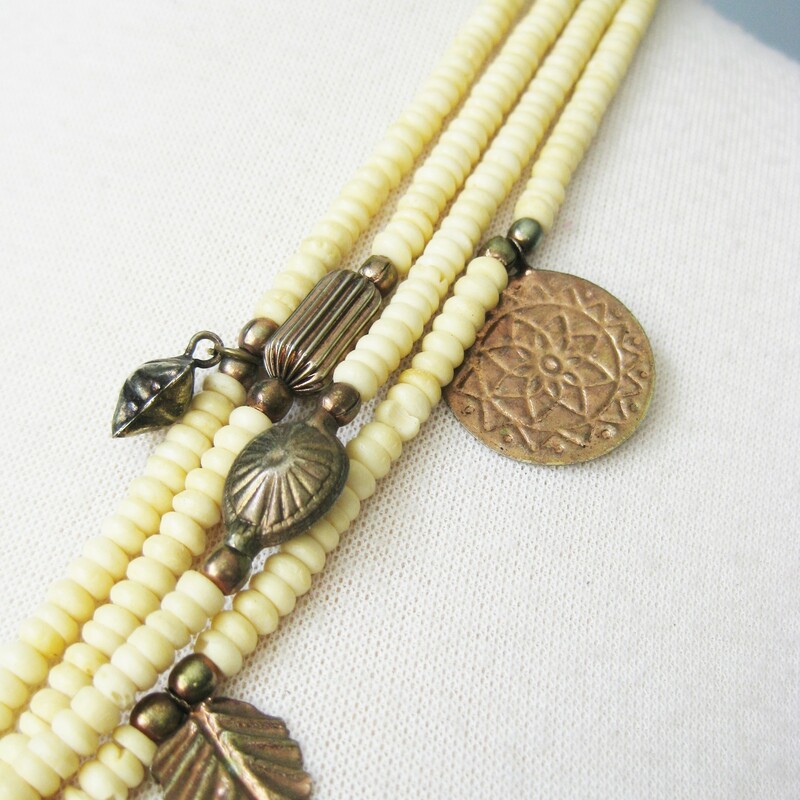 Wood And Brass, Ivory, Size: None<br />
Tribal style necklace made from multiple strands of ivory and orange beads, metal coins and charms<br />
<br />
Wear as shown or twist it into a choker length torsade.\\<br />
<br />
<br />
28.75in long<br />
closes with a silver toned hook<br />
<br />
thanks for looking!<br />
#40106