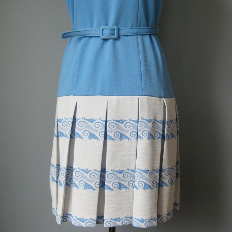 Darling day dress from the 1970s.<br />
No tags, poly double knit<br />
The dress is in the prettiest shade of sky blue and features a drop waist, flared pleated skirt and collar v neckline and a thin matching belt<br />
<br />
The print on the skirt are adorable waves with a precise and controlled vibe.<br />
<br />
Flat measurements:<br />
armpit to armpit: 36.5in<br />
waist: 16in<br />
hip: 17.5in<br />
length: 36.5in<br />
<br />
the belt is labeled size 10 which would be about a modern size 4<br />
<br />
excellent condition.<br />
thanks for looking!<br />
#401821