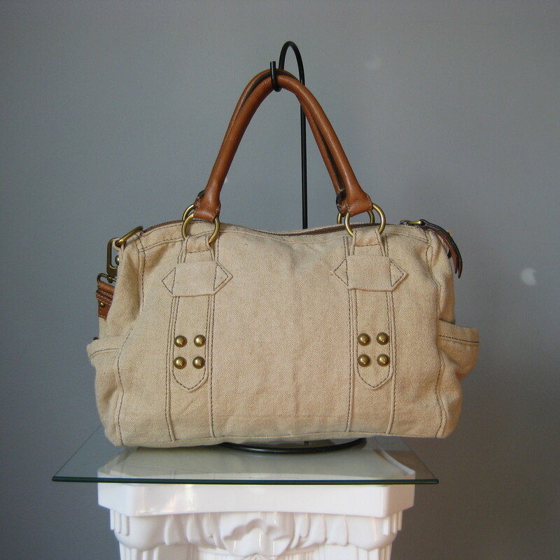 fabulous Fossil satchel in beige canvas with brown leather trim.
Double leather handles and a detachable adjustible web shoulder strap
Antique brass hardware
Key bag charm and leather luggage tag
two exterior slip pockets on the sides
Chevron striped fabric lining

Super clean inside and out
tiny bit of use on the brass hardware medallion

13in x 9in x 5in
Handle drop: 6.25in
Strap drop at max: 24.5in

Thanks for looking!
#18049

Please see my eBay store for other terrific Fossil and other bags