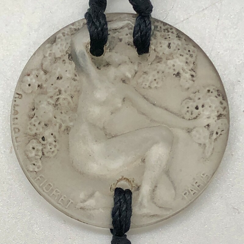 Fabulous and rare Rene Lalique Chose Promise Pendant.

This pendant was made by Rene Lalique as a decorative hangtag displayed outside the box for Fioret Chose Paris perfume (bottle by Baccarat). Although originally a medallion, they are used as pendants today. The knotted silk cords are original c.1924.

This is the only authentic hangtag made by Lalique for Fioret. It is clearly signed in the mold Fioret Paris and R. Lalique as seen in the photos. In excellent condition with virtually no nips or flea bites.