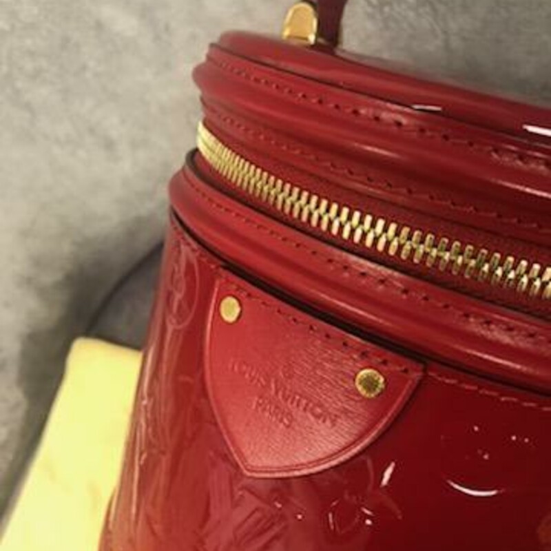 Authentic Louis Vuitton<br />
Cannes Red Leather Handbag<br />
2019 Louis Vuitton Cannes \"Rouge\" handbag was inspired by that indispensable piece of feminine luggage: its lush, cylindrical silhouette is crafted from lustrous Monogram Vernis embossed patent leather. With all the added details calf-leather trim, Toron top handle, removable, adjustable leather strap (drop: min. 50 cm/19.7 inches, max. 55 cm/21.7 inches) for shoulder or cross-body carry. Ideal for formal occasions, the Cannes handbag can be worn across the body or carried in the palm. Its cylindrical shape, roomy enough to hold all the necessary items, is made from embossed Monogram Vernis patent leather with a luxuriously glossy finish. The bag draws inspiration from traditional beauty cases and was designed for the Pre-Fall Collection.<br />
- Microfibre lining,<br />
- gold-tone hardware<br />
- zip closure<br />
- four protective bottom studs<br />
Material: Calf leather / Calf leather trim<br />
Dimensions: Height 17cm / 6.7\", Width 15cm / 5.9\", Depth 15cm / 5.9\".<br />
Made in France<br />
FL2129<br />
COMES WITH ORIGINAL DUST COVER!<br />
COMES with CERTIFICATE OF AUTHENTICITY<br />
This bag is in like new condition.  You can find this bag for resale on TRADESY right now for 3453.00 AND at Vintage by Misty has this bag for 3250.00<br />
This is an Amazing Price for such a Stunning Handbag!
