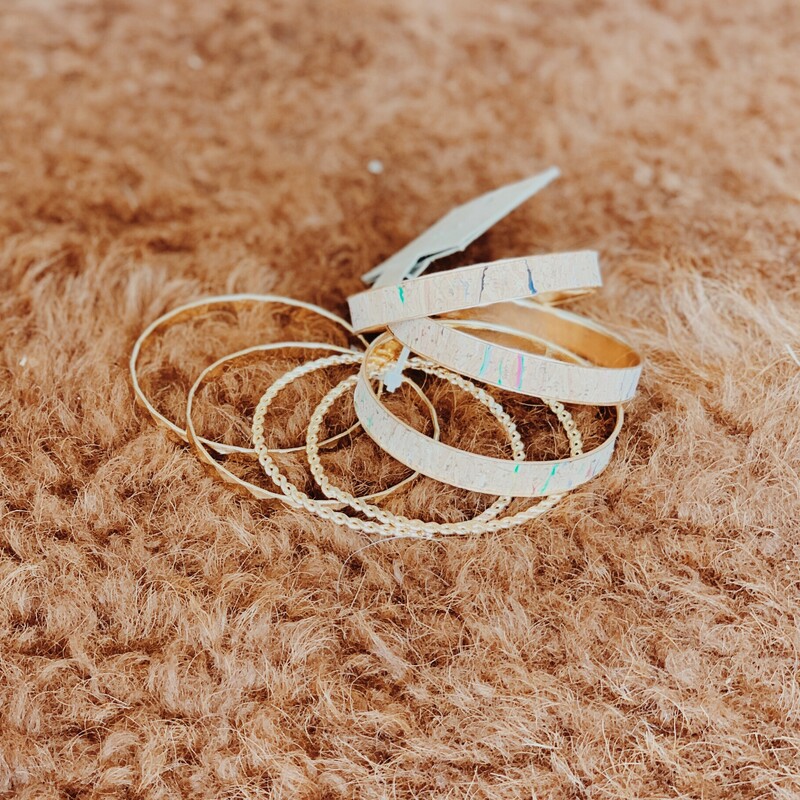 Beautiful set of seven bangles! Three with a cork detailing and four gold!