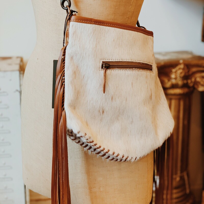 The perfect cowhide purse adorned with leather fringe! It measures 11 inches long by 10 inches wide and has two extra pockets.
Available in two different colors!
