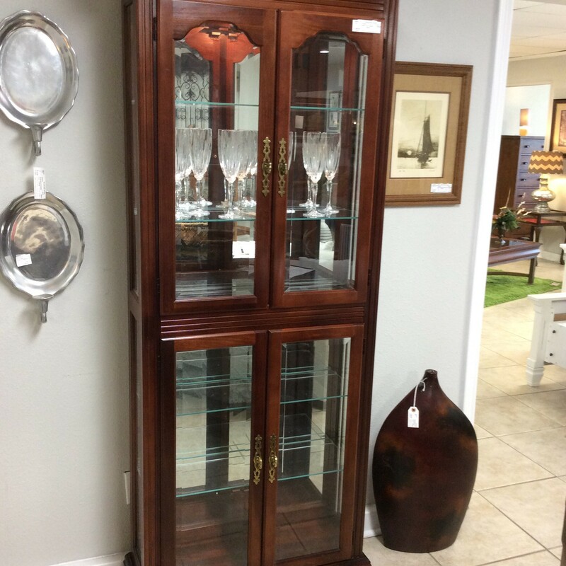 Beautiful Pulaski Curio Cabinet that lights up!
 This cabinet is a cherry wood and has four doors and four glass shelves. The hardware is gold.
Measures 31x10x77