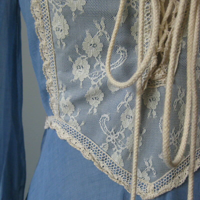 Vintage 1970s Gunne Sax Gown in blue cotton with white/offwhite lace trim.<br />
corset lace front<br />
Low neckline and sweeps up to cover the back of the neck<br />
Gathered skirt is quite full<br />
Juliet type sleeves, blue cotton from the shoulder to the forearm and then tight lace from there to the wrist.  The sleeves have zippers so you can get that tight look but still get in and out of the dress easily.<br />
It's fully lined in white/offwhite soft acetate<br />
<br />
<br />
Almost like new condition.  I found one small hole in the lining as shown and the corset lacing has a brown area also shown.<br />
<br />
Here are the flat measurements please double where appropriate<br />
Shoulder to shoulder: 13<br />
Amrpit to Armpit: 17<br />
Waist: 13<br />
Hips: 20<br />
Length: 57<br />
<br />
Thank you for looking.<br />
#43206