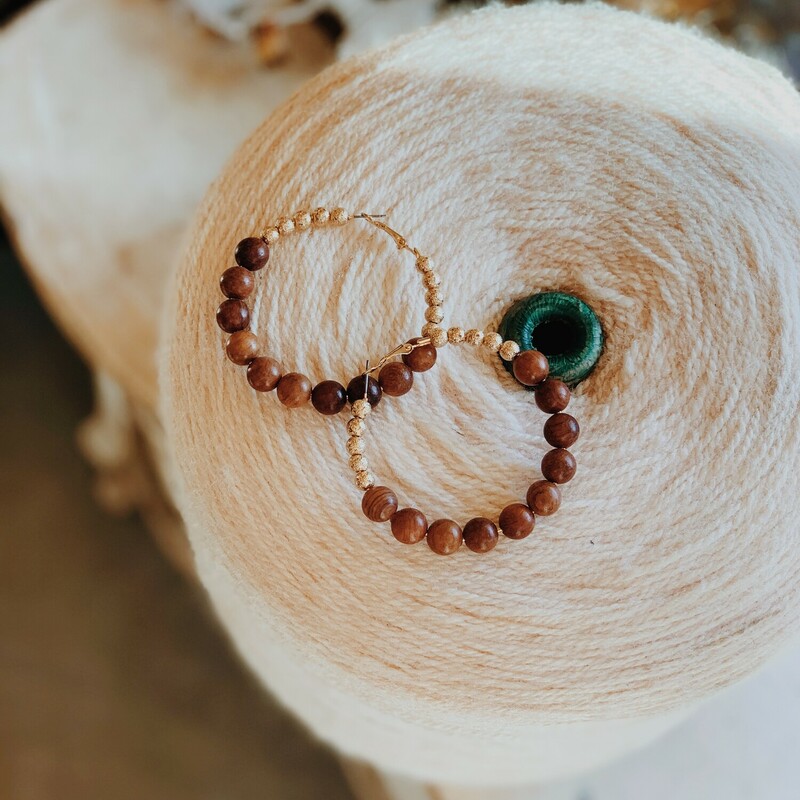 This adorable pair of hoops is outfited in wooden beads along with gold beads. The circle of the hoop is 2.5 inches across.