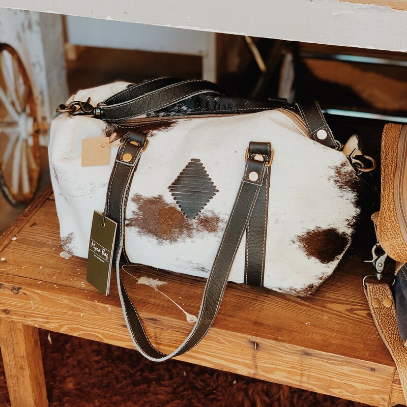 Our Myra mini duffle is perfect for overnight uses or as an everyday purse! This cowhide bag has three pockets on the inside and an adjustable leather strap!

Measurements: 10 inches tall x 16 inches wide x 5 inches deep