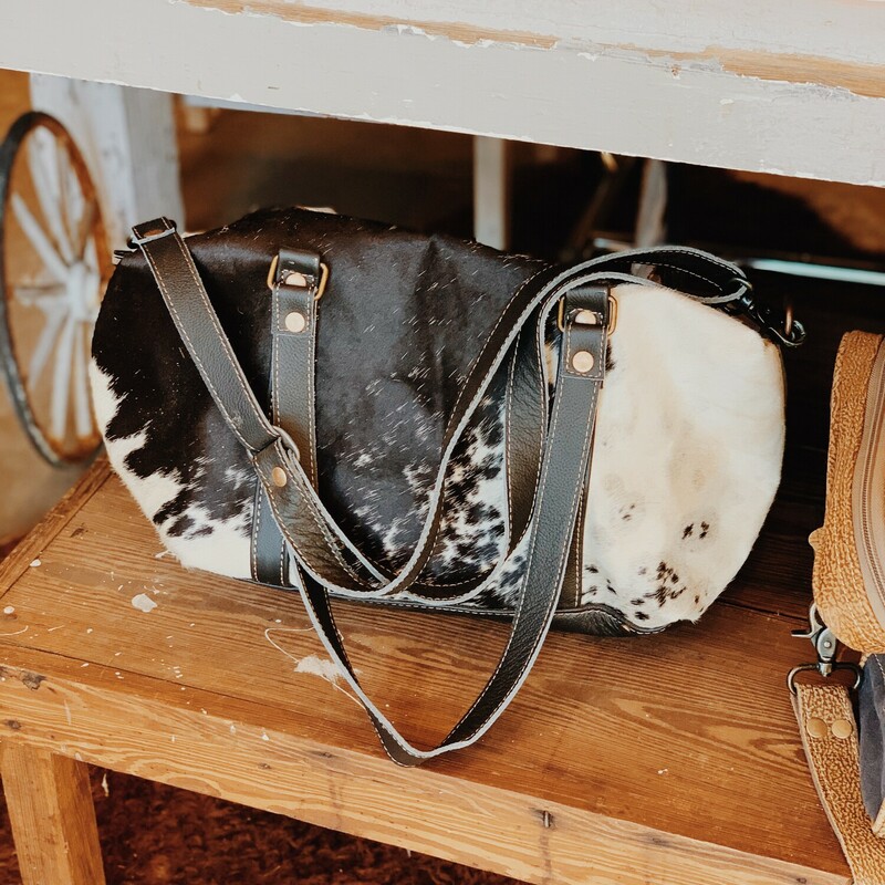 Our Myra mini duffle is perfect for overnight uses or as an everyday purse! This cowhide bag has three pockets on the inside and an adjustable leather strap!

Measurements: 10 inches tall x 16 inches wide x 5 inches deep