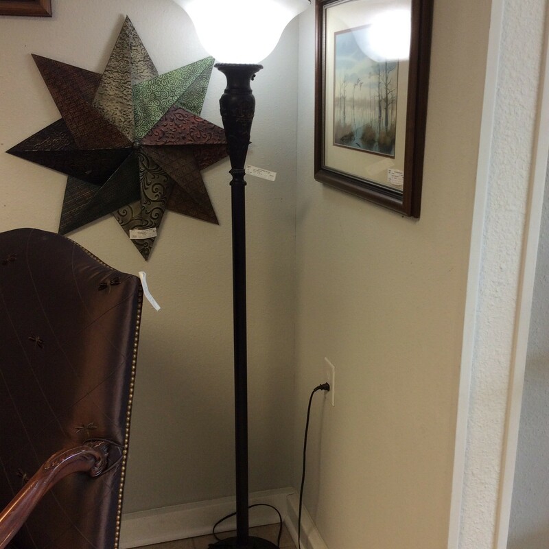 This floor lamp features a tall, slim black base with vintagy embellishments and a white uplight.