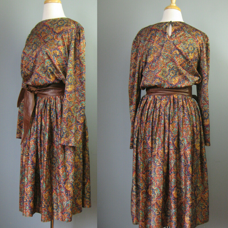 Vtg Bedford Fair Secretar, Jewel, Size: Large<br />
Here is a pretty paisley secretary dress from the 1970s.  It's made of a silky fluid polyester and it is by Bedford Fair.  You pull it on over the head.  It has one button at the back of the neck and an elastic waist.<br />
The colors are teal gold burgundy and purple but it gives off a warm tone brown vibe.  I've paired it with a gorgeous brown leather obi belt that is NOT INCLUDED but available separately.  I think they look great together<br />
Long sleeve<br />
Unlined<br />
Flat measurements:<br />
Shoulder to shoulder: 18<br />
armpit to armpit: 21.25<br />
Waist: 13 to 21<br />
Hip: free<br />
Length: 45<br />
Underarm sleeve seam: 16.5<br />
perfect condition!<br />
<br />
Thanks for looking!<br />
#15936
