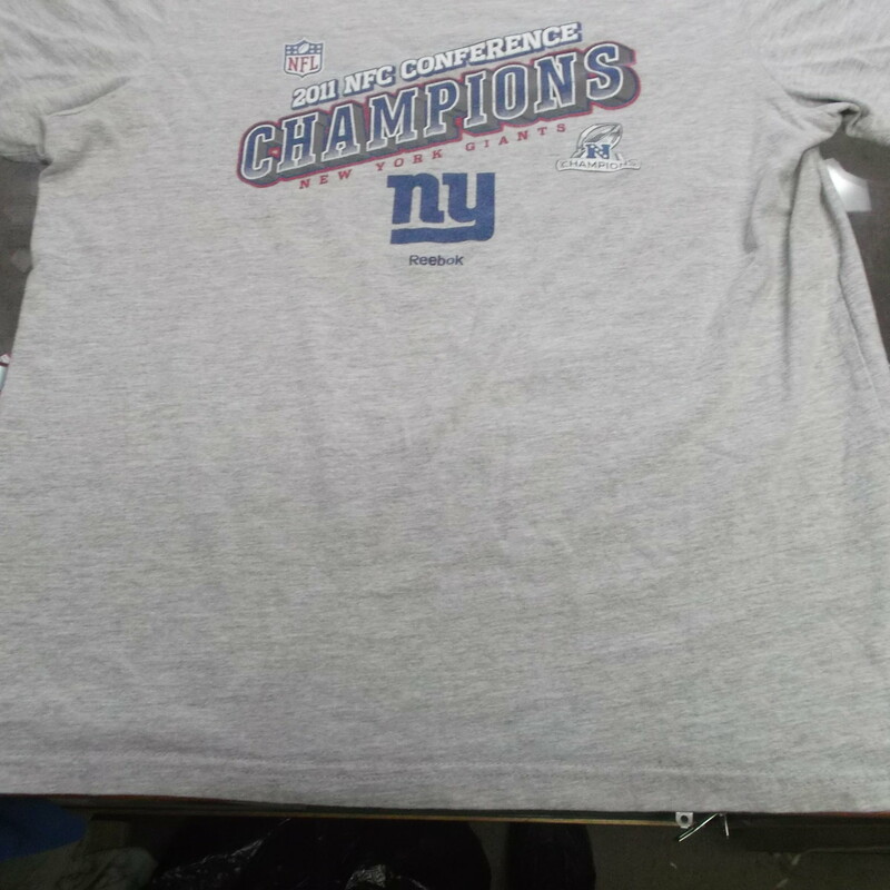 New York Giants 2011 Champions Women's Reebok Shirt Size Medium Gray #9476<br />
Rating:   (see below) 4 - Fair Condition<br />
Team: New York Giants<br />
Event: 2011 NFC Champions <br />
Brand: Reebok<br />
Size: Medium - Women's(Measured Flat: Across chest 19\"; Length 24\") <br />
Color: Gray<br />
Style: short sleeve screen pressed Logo<br />
Material: 93 Cotton 7 Polyester<br />
Condition: - Fair Condition - wrinkled; Logo is faded and discolored; Significant pilling and fuzz; Material feels coarse; Definite signs of use; No stains rips or holes (Please use photos to see the condition details) <br />
Shipping cost: $3.37  <br />
Item #: 9476