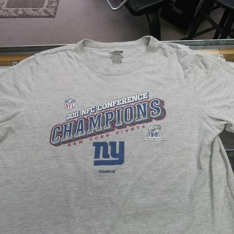 New York Giants 2011 Champions Women's Reebok Shirt Size Medium Gray #9476<br />
Rating:   (see below) 4 - Fair Condition<br />
Team: New York Giants<br />
Event: 2011 NFC Champions <br />
Brand: Reebok<br />
Size: Medium - Women's(Measured Flat: Across chest 19\"; Length 24\") <br />
Color: Gray<br />
Style: short sleeve screen pressed Logo<br />
Material: 93 Cotton 7 Polyester<br />
Condition: - Fair Condition - wrinkled; Logo is faded and discolored; Significant pilling and fuzz; Material feels coarse; Definite signs of use; No stains rips or holes (Please use photos to see the condition details) <br />
Shipping cost: $3.37  <br />
Item #: 9476