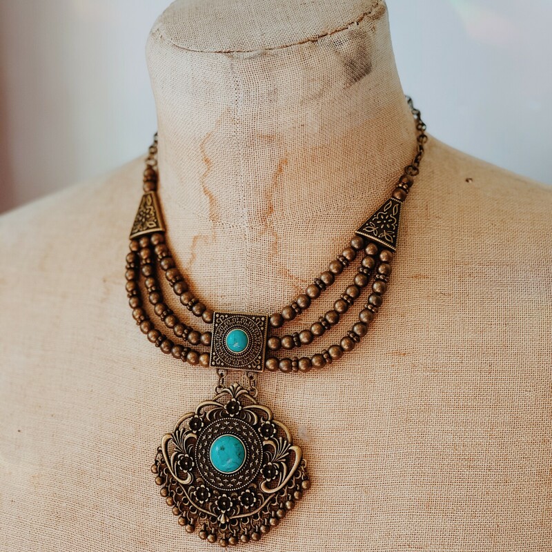 This beautiful brass colored necklace features two turquoise colored stones! It is a 16 inch chain with a 3.5 inch extender.