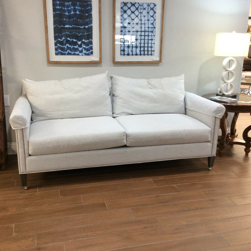 This sofa is stunning! Originally from Donna's Fine Furnishings it is in pristeen condition. Upholstered in linen, the most serene shade of white, almost a silvery opalescence. It features a bold double nailhead trim and sits on casters. Refined and elegant.