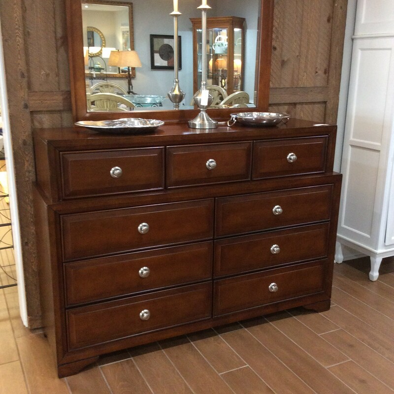 Very pretty contemporary nine drawer dresser with beveled mirror. The dresser is a dark brown with silver hardware.