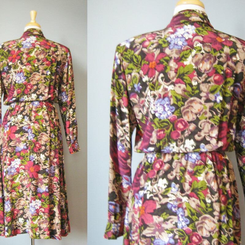Here is a pretty silk secretary dress from the 1980s.  It's made of a silk in a sophisticated ikat style floral print.  The surplice neckline closes with buttons and hooks, it's really securely together in the front.  Elastic Waist. Unlined.  Removable shoulder pads snap off and on.<br />
<br />
The colors are burgundy, olive green and blue but it gives off a warm tone bronazy vibe.<br />
<br />
Long sleeve<br />
<br />
Flat measurements:<br />
Shoulder to shoulder: 16.34<br />
armpit to armpit: 19<br />
Waist: 12 to 15<br />
Hip: free<br />
Length: 46.25<br />
Underarm sleeve seam: 18.5 (sleeve buttons at the end)<br />
<br />
perfect condition!<br />
<br />
Thanks for looking!<br />
#36266