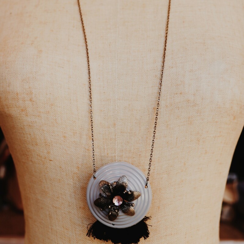 This hand crafted necklace features a bakelite escutcheon as its pendant. It is on a 34 inch chain.