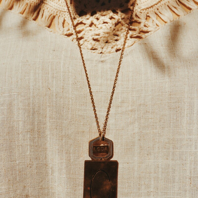 This unique necklace has a C engraved brass plate and hangs from a 30 inch chian!